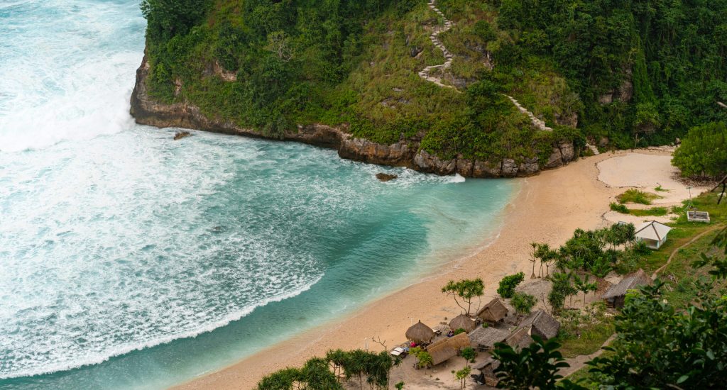 View of tropical beach, sea rocks and turquoise ocean, blue sky.