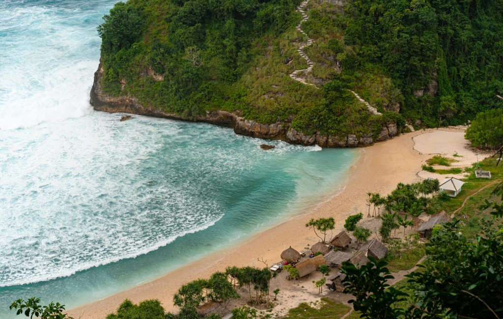 View of tropical beach, sea rocks and turquoise ocean, blue sky.